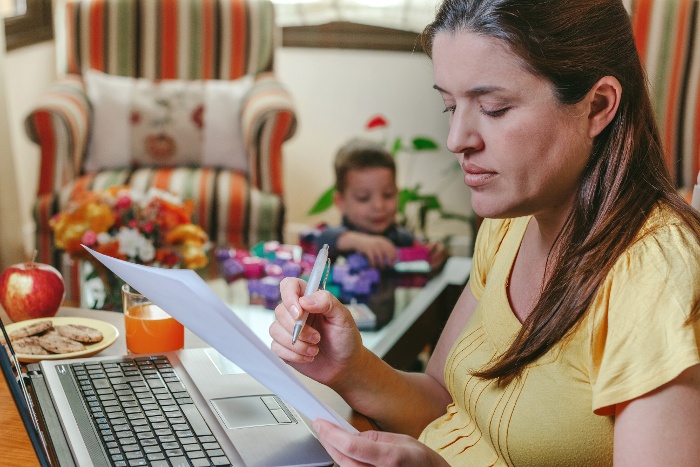 mother-working-laptop-living-room-while-her-son-plays-1